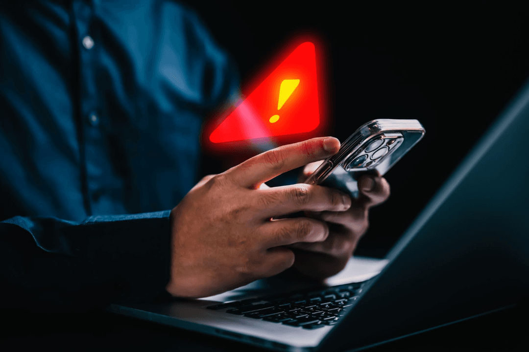 Person holding a phone showing a scam warning